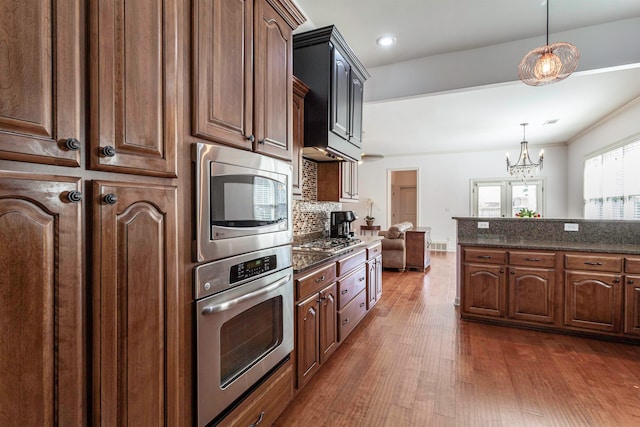 kitchen with pendant lighting, dark hardwood / wood-style floors, a notable chandelier, stainless steel appliances, and ornamental molding