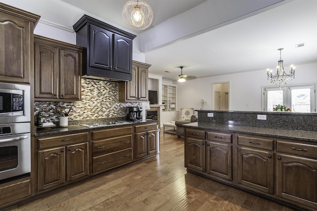 kitchen featuring pendant lighting, dark hardwood / wood-style flooring, dark brown cabinetry, and appliances with stainless steel finishes