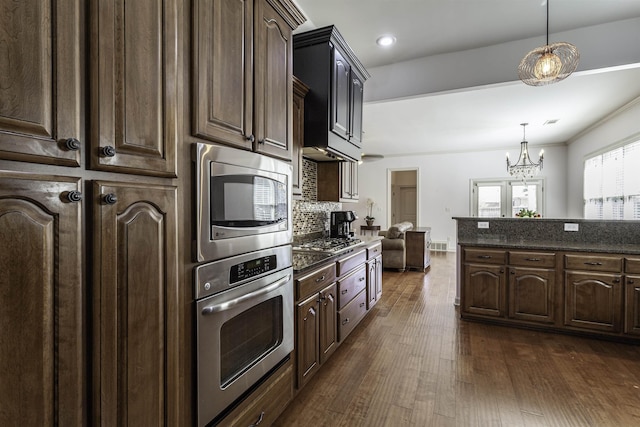 kitchen featuring stainless steel appliances, decorative light fixtures, dark hardwood / wood-style flooring, and dark brown cabinets