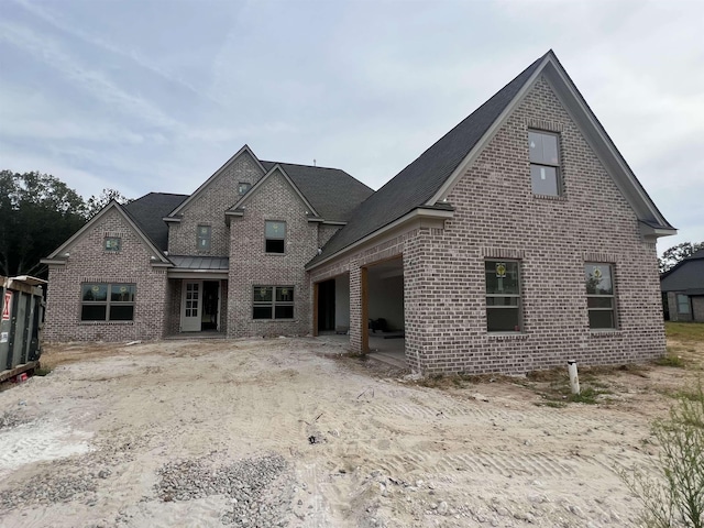 rear view of house with brick siding and an attached garage