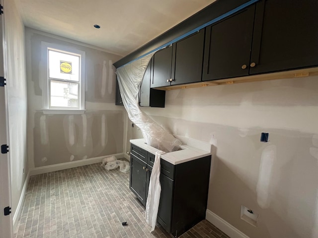 clothes washing area with baseboards