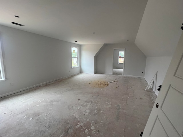 additional living space with plenty of natural light, visible vents, and vaulted ceiling