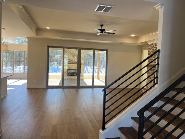 interior space featuring a healthy amount of sunlight, a raised ceiling, visible vents, and crown molding