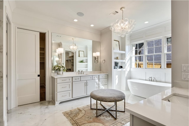 bathroom featuring built in features, a chandelier, vanity, ornamental molding, and a bath