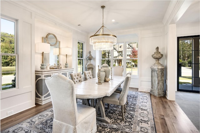 dining area with crown molding, dark wood-type flooring, and a notable chandelier