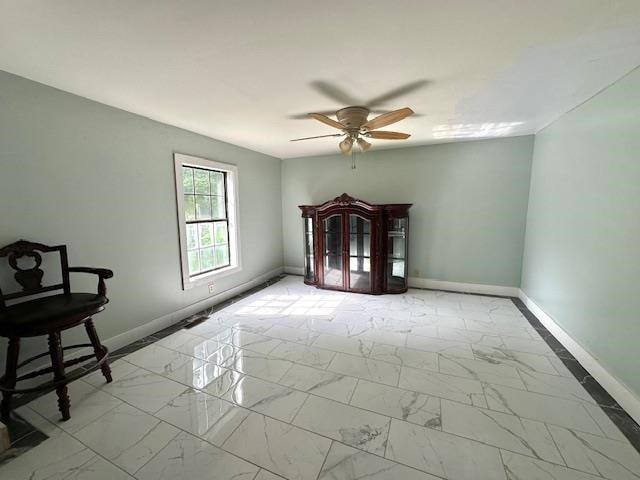 spare room featuring ceiling fan and light tile patterned floors