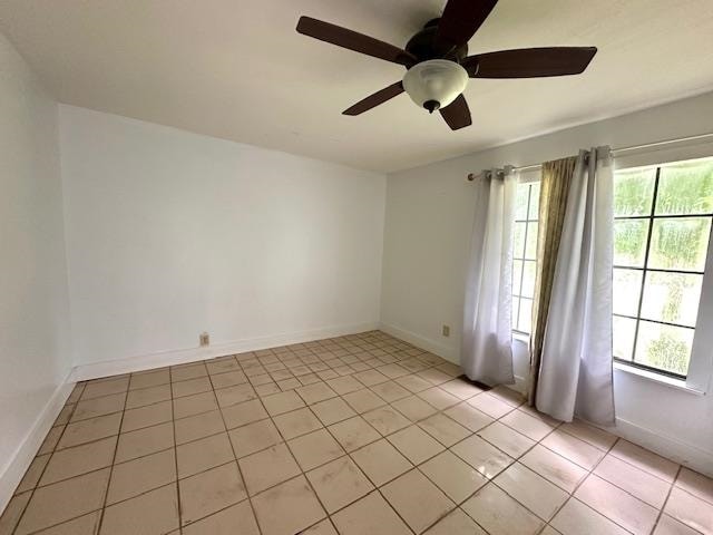 tiled spare room featuring ceiling fan and plenty of natural light