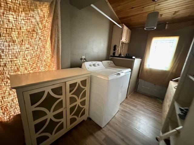 laundry area featuring hardwood / wood-style floors, wood ceiling, independent washer and dryer, and cabinets