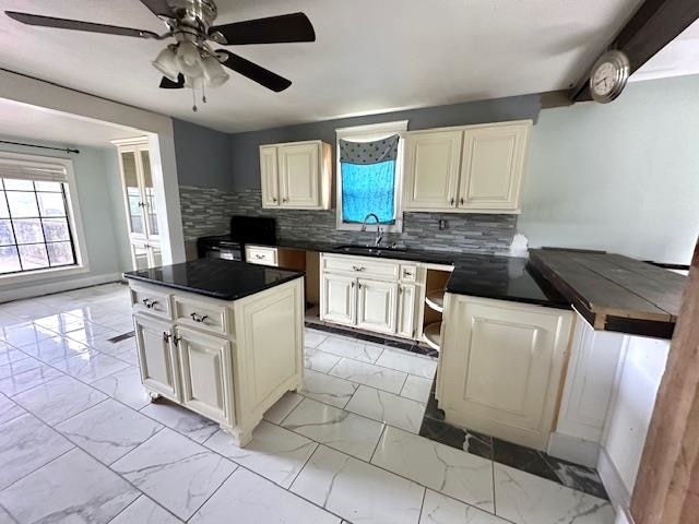 kitchen with light tile patterned flooring, a wealth of natural light, and backsplash