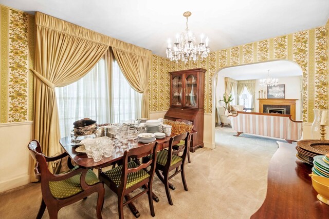 carpeted dining space with an inviting chandelier