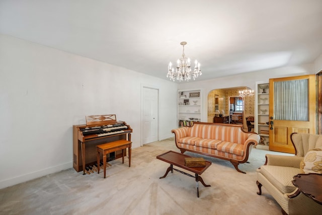 living area with built in features, arched walkways, light carpet, a chandelier, and baseboards