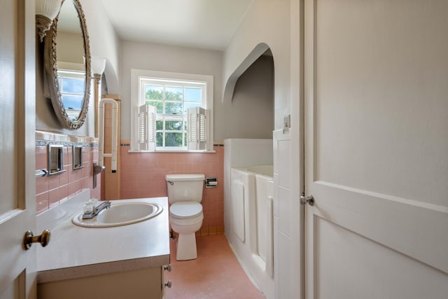 bathroom featuring tile walls, toilet, wainscoting, vanity, and tile patterned flooring