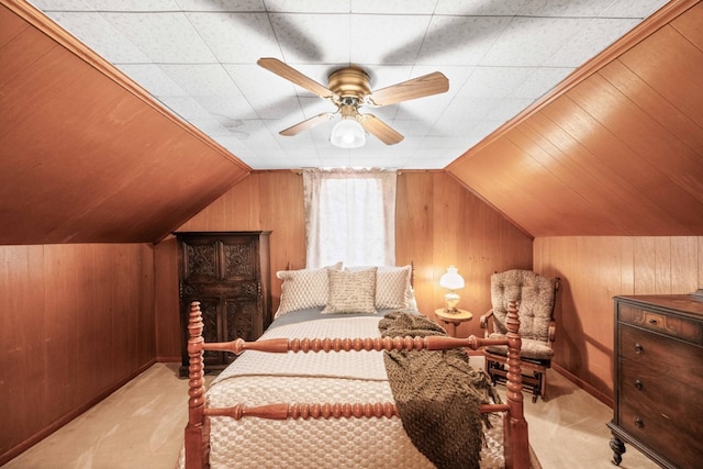 carpeted bedroom featuring ceiling fan, vaulted ceiling, and wooden walls