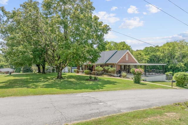 view of front of home featuring brick siding, covered porch, and a front yard