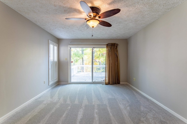 carpeted spare room with ceiling fan and a textured ceiling