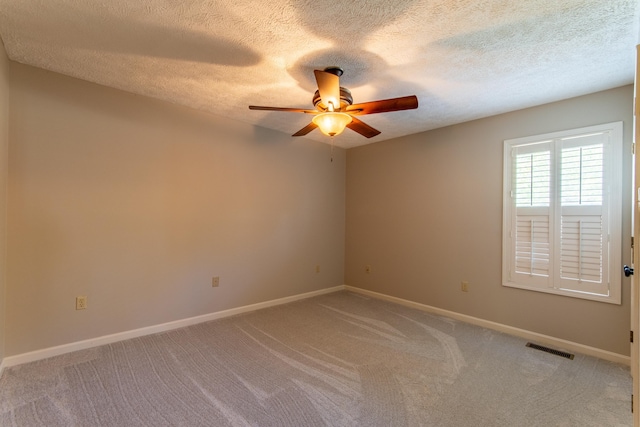 carpeted spare room with ceiling fan and a textured ceiling