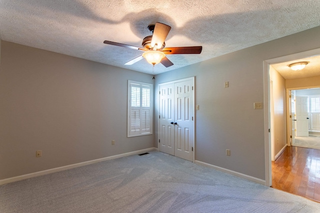 unfurnished bedroom with carpet floors, a textured ceiling, and a closet