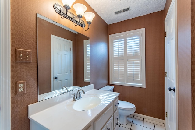 bathroom featuring vanity, tile patterned floors, toilet, and a textured ceiling