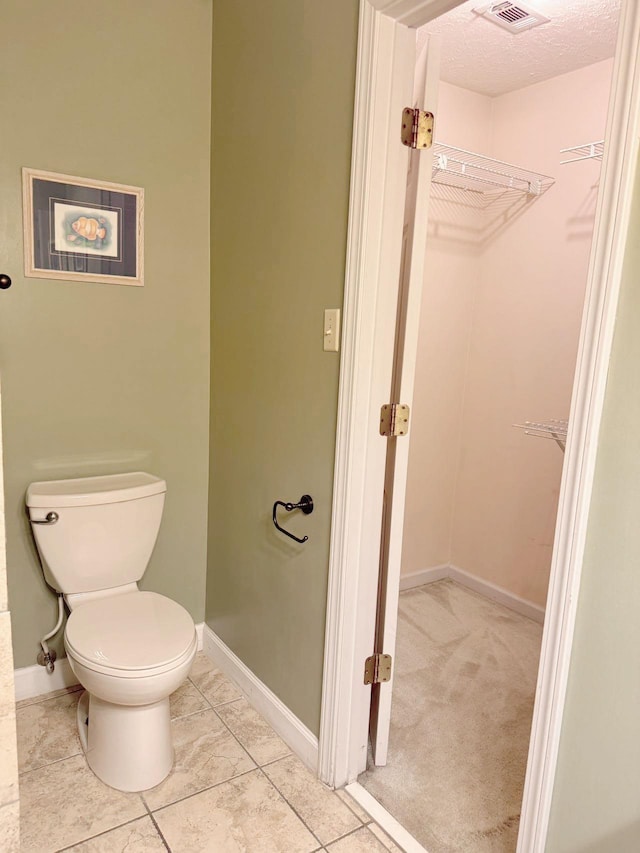 bathroom with a textured ceiling and toilet