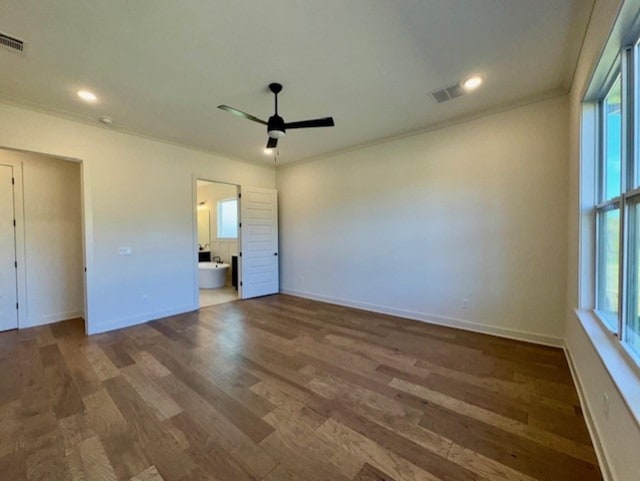 unfurnished bedroom with baseboards, crown molding, visible vents, and dark wood-type flooring