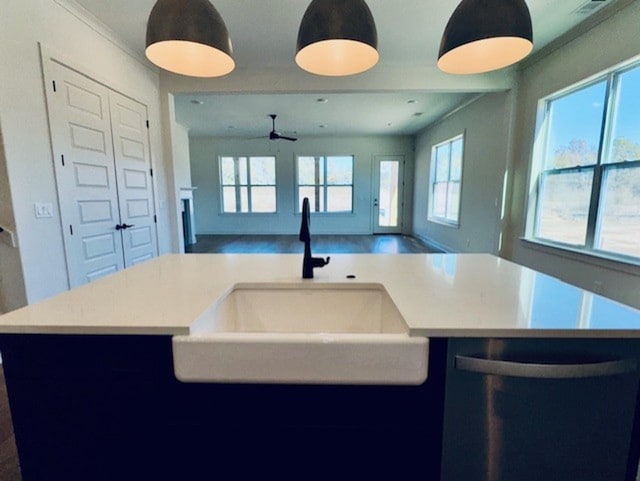 kitchen featuring an island with sink, light countertops, a sink, and open floor plan