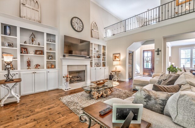 living room with dark wood-type flooring and a towering ceiling