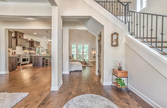 entryway with a towering ceiling, french doors, and dark hardwood / wood-style floors