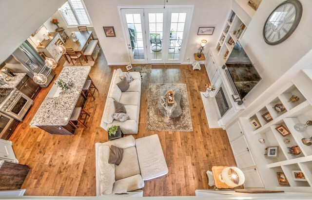 living room with french doors, built in shelves, hardwood / wood-style flooring, and plenty of natural light