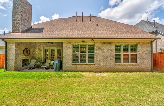 rear view of house with a lawn and a patio