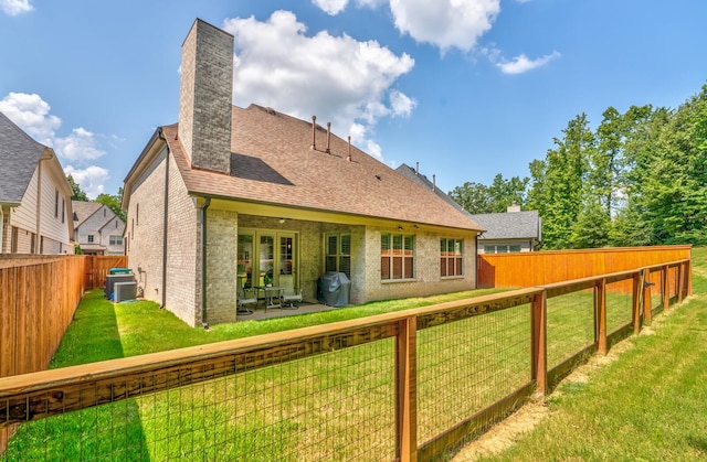 back of house featuring a patio and a lawn