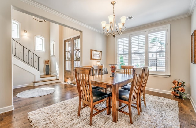 dining room featuring an inviting chandelier, dark wood-type flooring, ornamental molding, and a healthy amount of sunlight