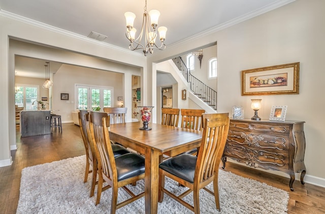 dining space featuring a notable chandelier, crown molding, and dark hardwood / wood-style floors