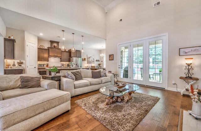 living room featuring dark hardwood / wood-style flooring, a high ceiling, and crown molding