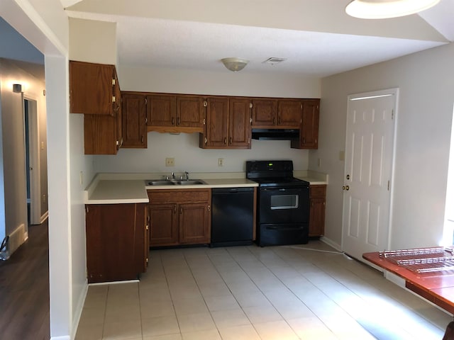 kitchen featuring black appliances, sink, light hardwood / wood-style flooring, and extractor fan