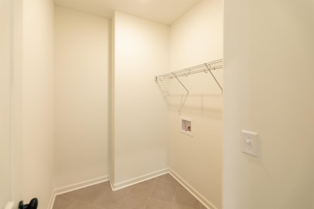 laundry area featuring washer hookup, laundry area, tile patterned flooring, and baseboards