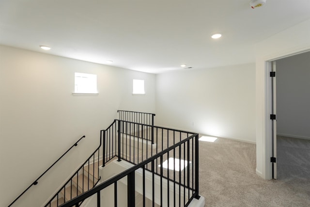 interior space featuring baseboards, carpet flooring, an upstairs landing, and recessed lighting