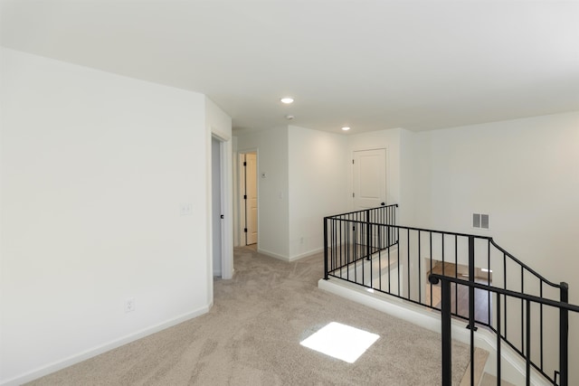 hallway featuring carpet, recessed lighting, visible vents, an upstairs landing, and baseboards