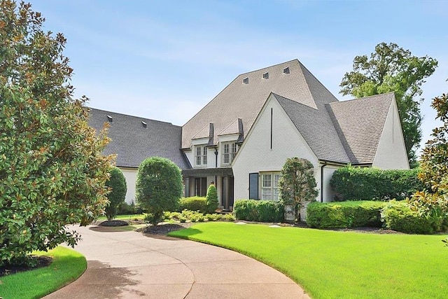 english style home featuring a front lawn