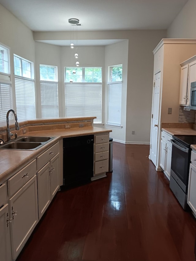 kitchen with dark wood-style flooring, decorative light fixtures, stainless steel appliances, white cabinetry, and a sink