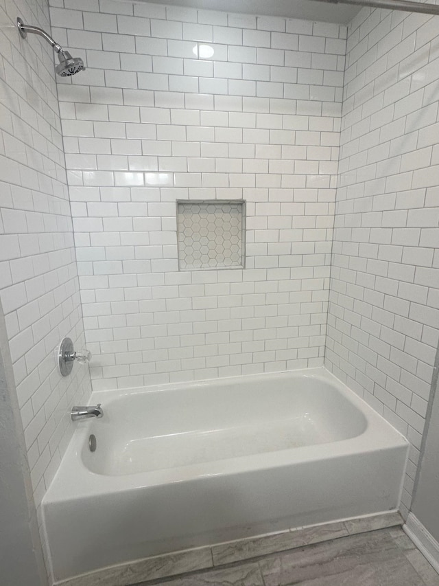 bathroom featuring tiled shower / bath and wood-type flooring