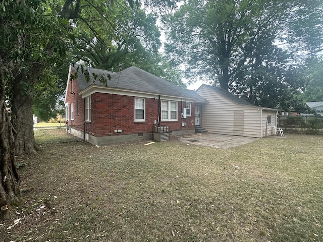 back of property with a yard and a patio