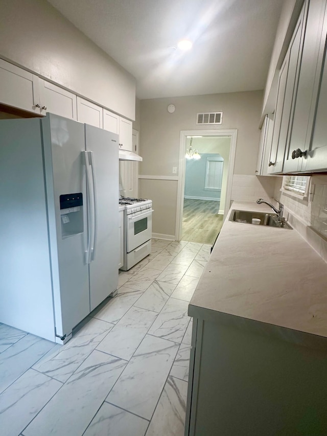 kitchen featuring sink, white appliances, and decorative backsplash