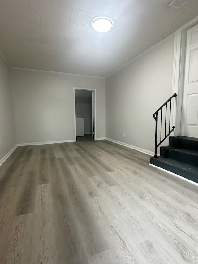 interior space featuring hardwood / wood-style flooring, ornamental molding, and washer / clothes dryer