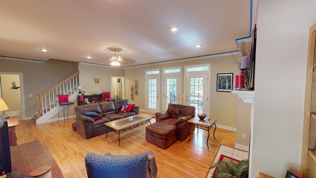 living room featuring light wood-style floors, stairs, baseboards, and recessed lighting