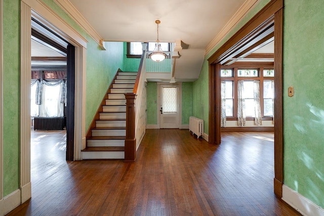 entrance foyer with a notable chandelier, stairs, radiator heating unit, and hardwood / wood-style flooring
