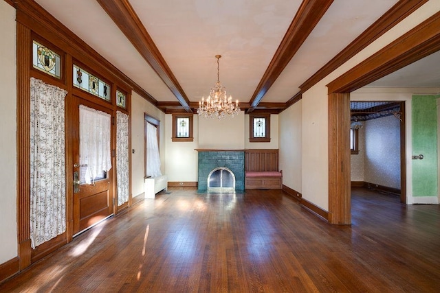 foyer entrance with a brick fireplace, crown molding, wood finished floors, and beamed ceiling