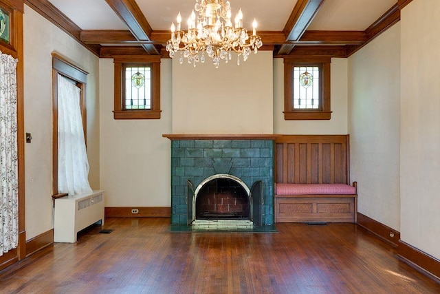 unfurnished living room featuring a brick fireplace, ornamental molding, wood finished floors, and a chandelier