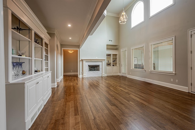 unfurnished living room with ceiling fan, hardwood / wood-style floors, a high end fireplace, and built in shelves