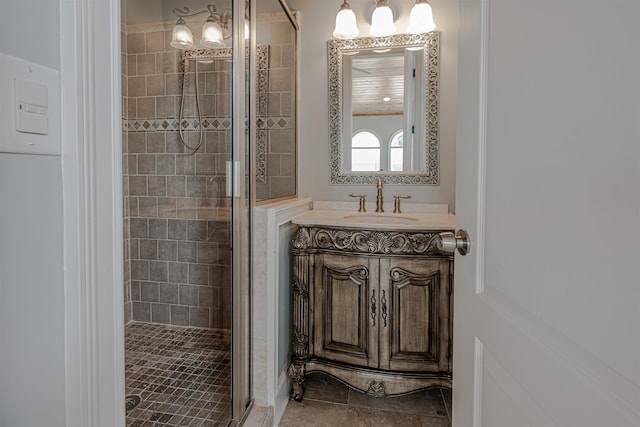 bathroom with a shower with shower door, tile patterned flooring, and vanity