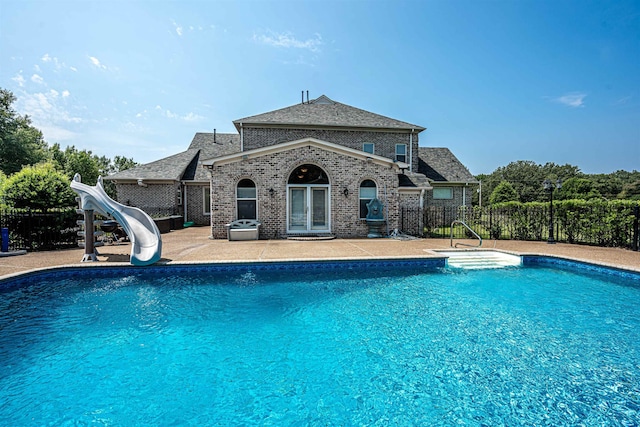 view of swimming pool with a patio and a water slide